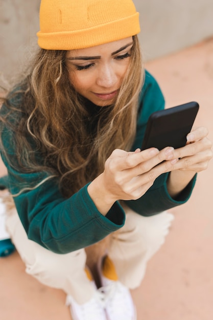 電話を使用してスケートボード上の女性