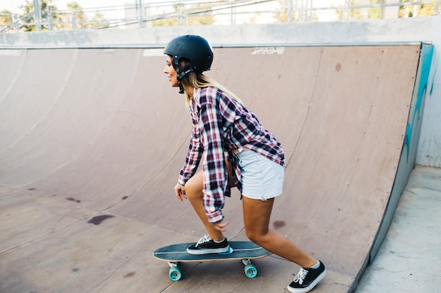 Woman skateboarding with helmet sideways