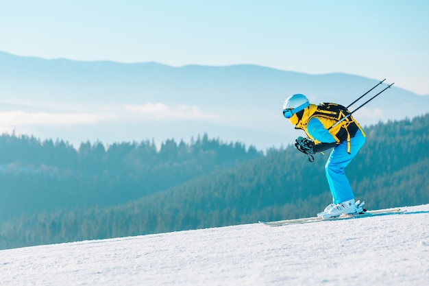 Женщина катается на лыжах по зимнему склону гор на фоне