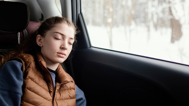 旅行中に車で寝ている女性