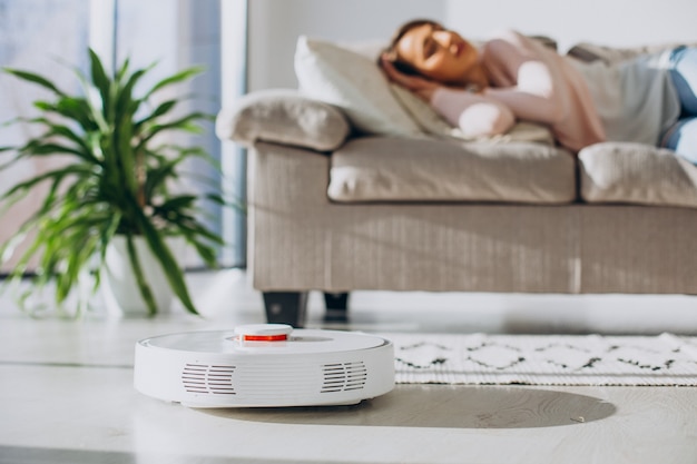 Free photo woman sleeping on sofa, vacuum cleaner doing housework