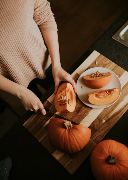 Woman slicing pumpkin for Thanksgiving dinner food photography