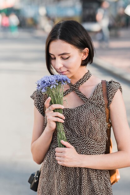Woman smelling flowers on street