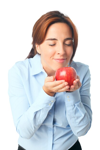 Женщина нюхает красное яблоко