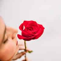 Free photo woman smelling on red rose