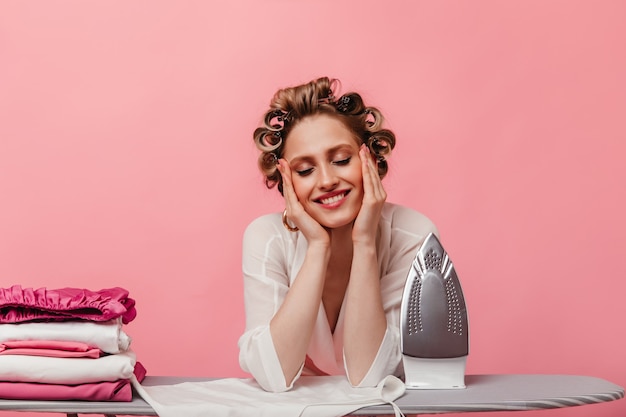 Woman smiles happily, ironing all her clothes