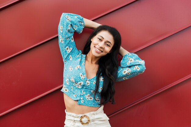 Woman smiling at camera and holding her hands behind head