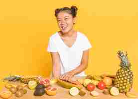 Free photo woman smiling at camera behind a table with fruits