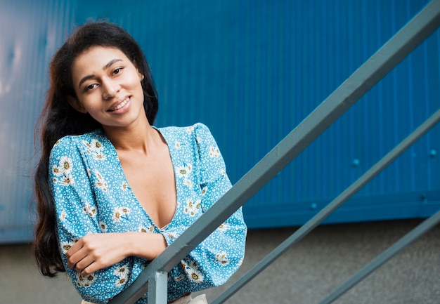 Woman smiling and looking at camera from the stairs