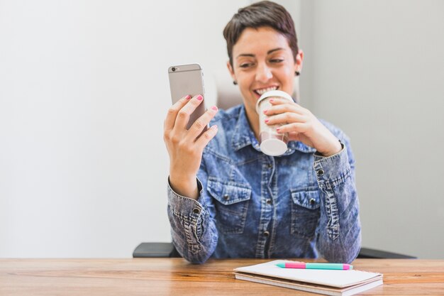 woman smiling and looking at her mobile phone