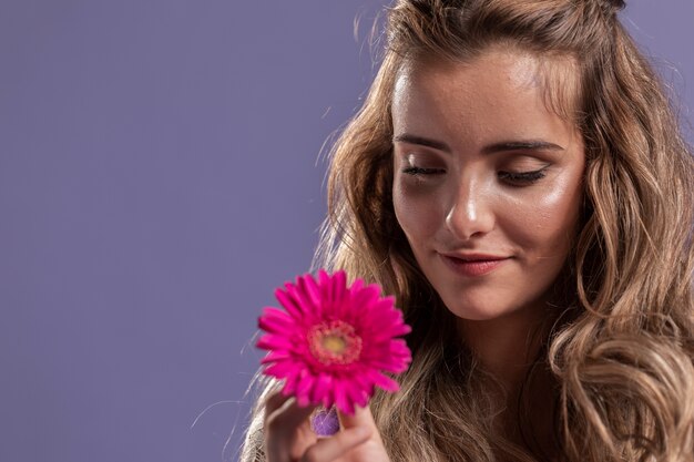 Woman smiling while holding a chrysanthemum with copy space