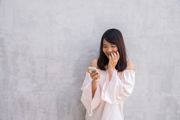 彼女の携帯電話を見ながら女性が笑顔