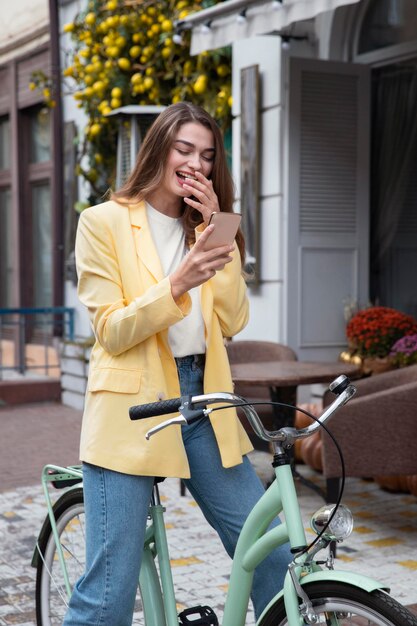 スマートフォンを見て、自転車に座って笑っている女性