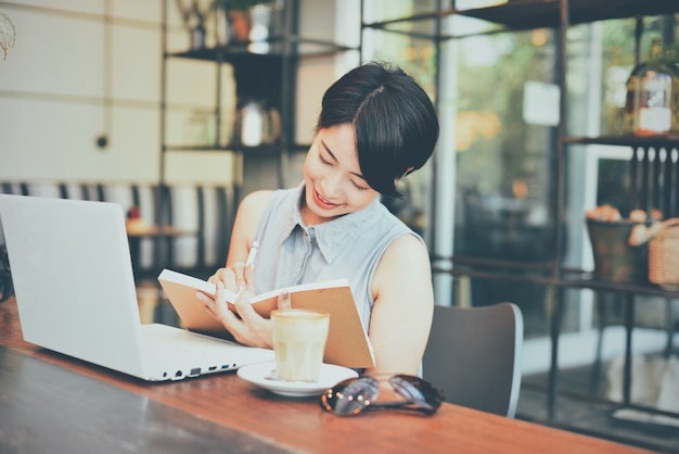 Woman smiling while writing in an agenda