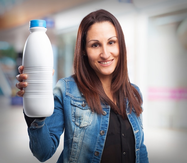 Woman smiling with a bottle of milk