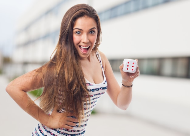 Woman smiling with a dice with the face of the six