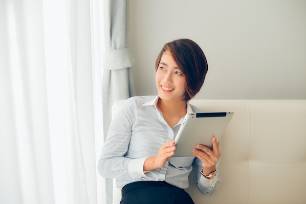 Woman smiling with a tablet in hands