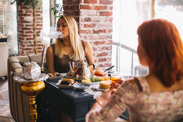 Woman smoking hookah at the restaurant