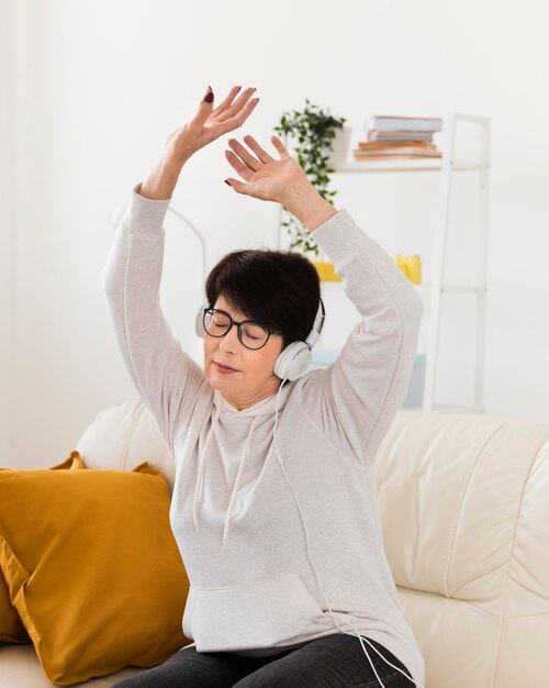 Woman on sofa listening to music on headphones