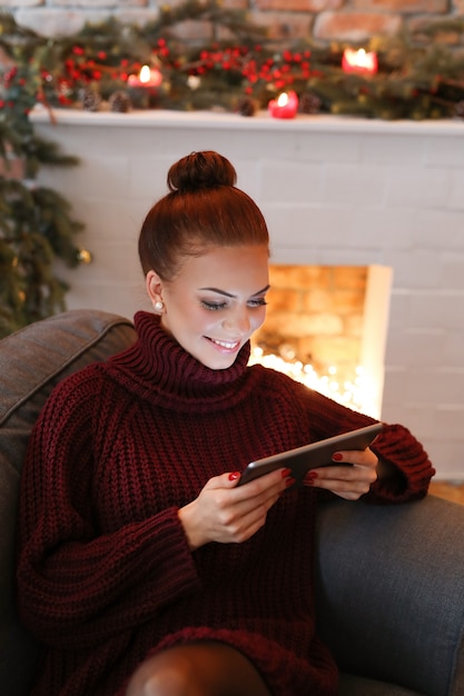 タブレットが付いているソファーの女性