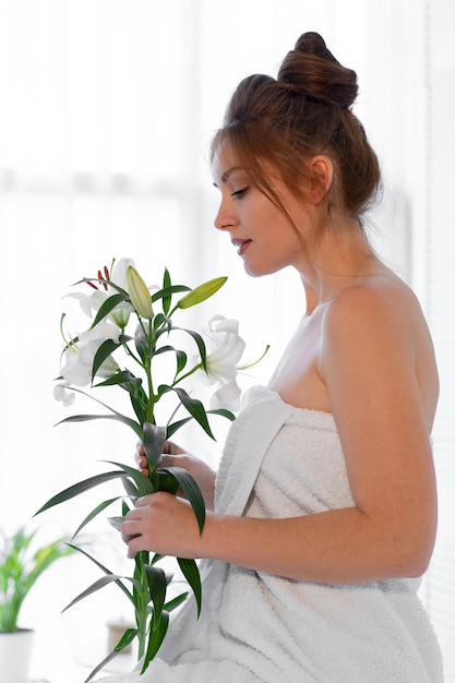 Free photo woman at the spa holding lilies