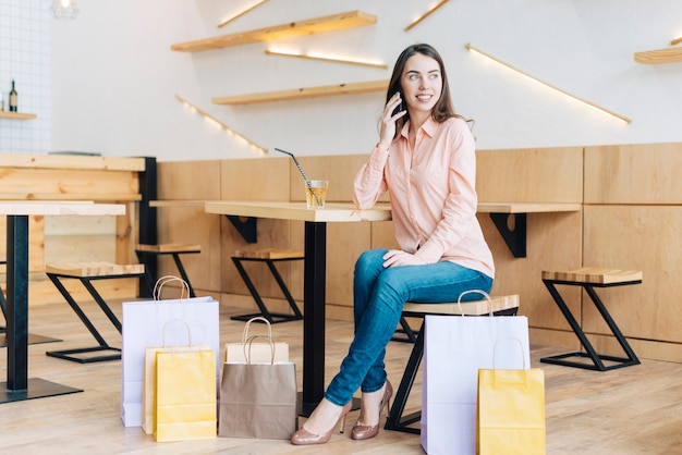 Foto gratuita donna che parla sul telefono dopo lo shopping