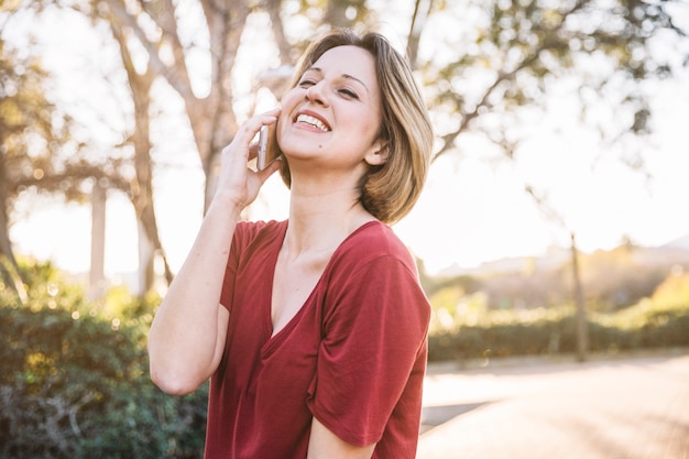 Woman speaking on phone on park alley