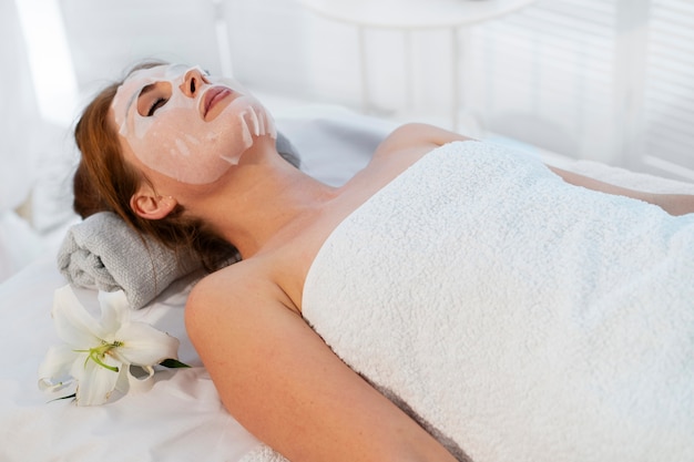 Donna che trascorre del tempo alla spa con un trattamento con maschera facciale