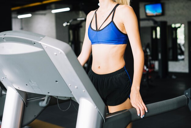 Woman in sports bra walking on treadmill