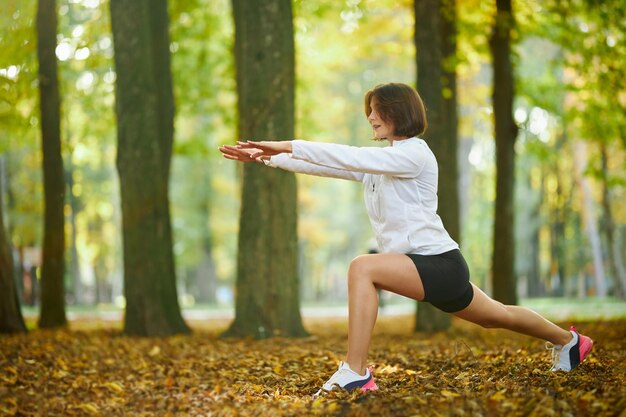 Женщина в спортивной одежде делает упражнения на растяжку тела