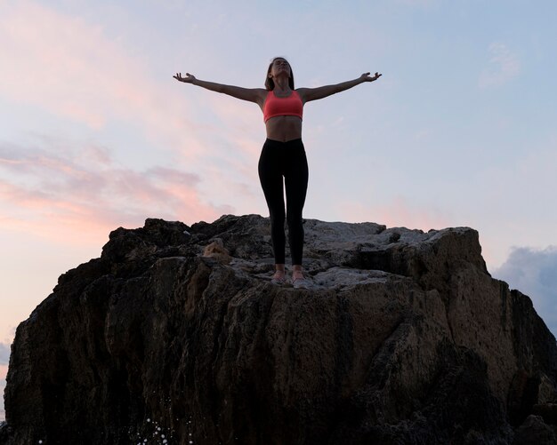 Woman in sportswear standing on a coast