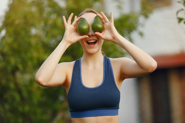 Woman in a sportwear holds a fruits