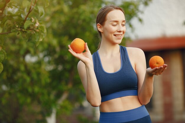 Woman in a sportwear holds a fruits