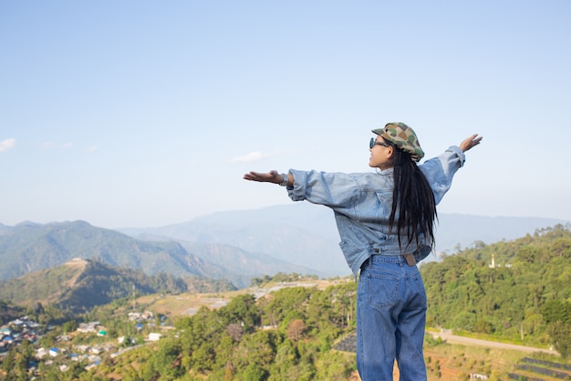 woman spread arms in the middle of a high trees nature forest