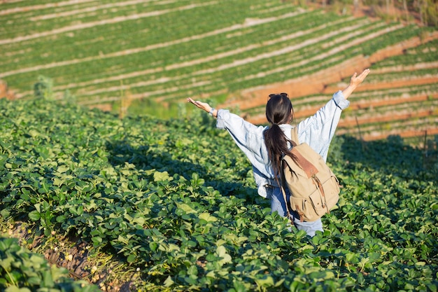 Woman spread arms in strawberry farm