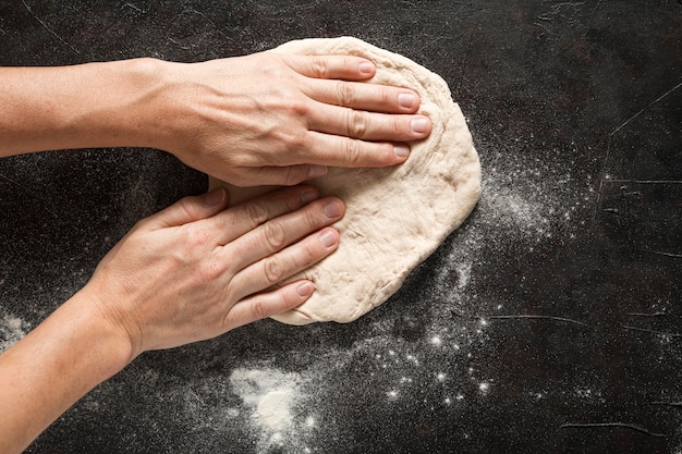 Free photo woman spread pizza dough