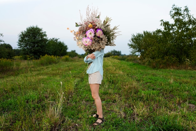 Foto gratuita donna in primavera che tiene il mazzo di fiori