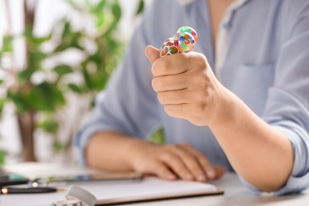 Woman squeezing colorful slime in office closeup Antistress toy