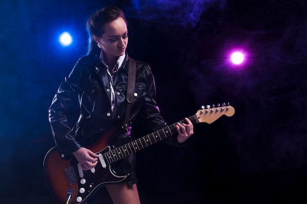 Foto gratuita donna sul palco con una chitarra e un cinturino