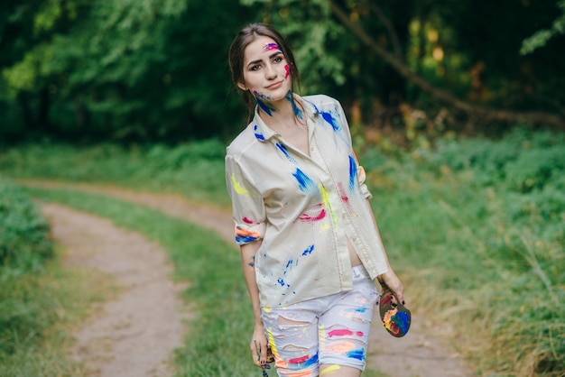 Женщина окрашивали краской ходьбе на грунтовой дороге