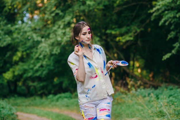 Woman stained by paint walking on a forest