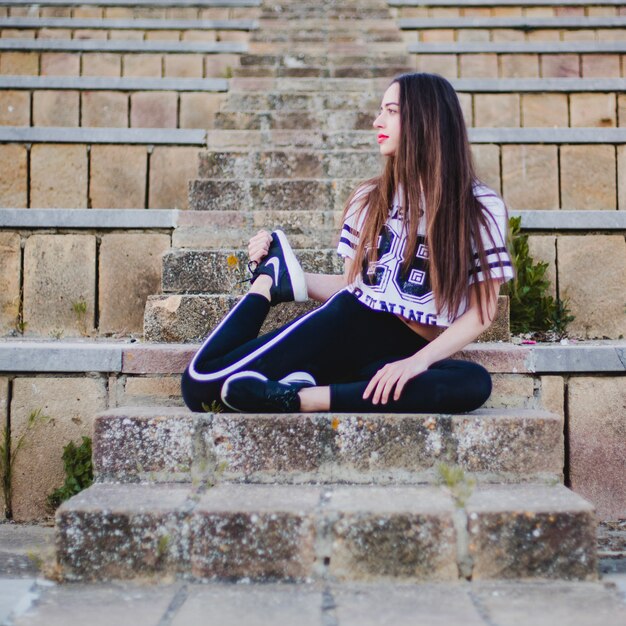 Woman on stairs stretching leg