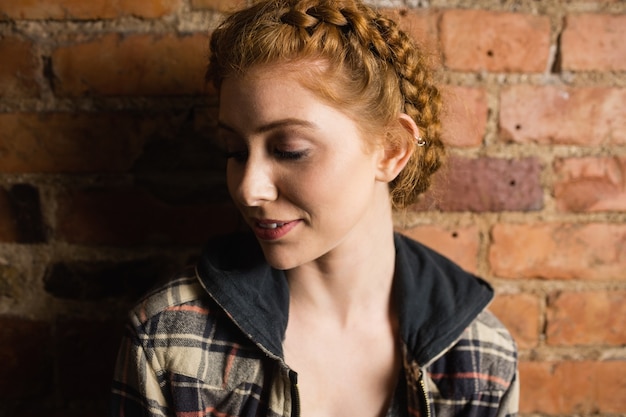 Free photo woman standing against brick wall