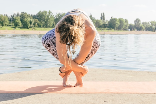 Free photo woman standing in asana at water