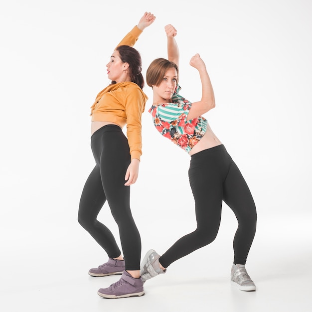 Woman standing back to back dancing on white backdrop