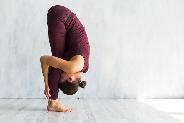 Woman standing in big toe yoga pose