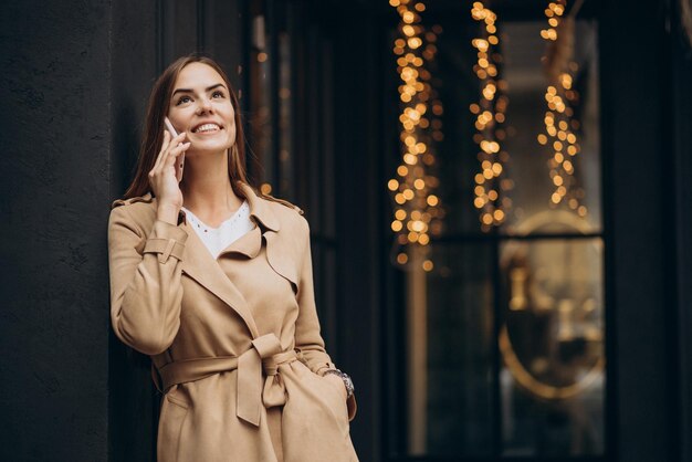 カフェのそばに立って電話を使っている女性