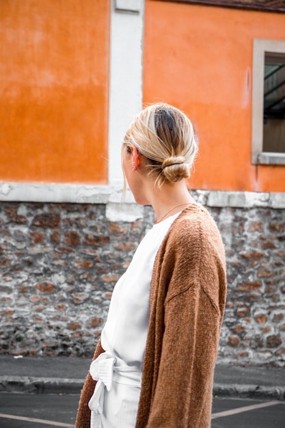 Free photo woman standing by the sidewalk facing to the side