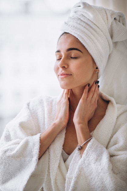 Woman standing by the window in bathrobe