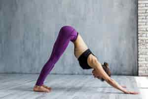 Free photo woman standing in a downward-facing dog yoga pose